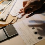 About Detailed view of fingerprinting process with documents and ink pad on a desk, focusing on identity verification.